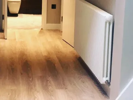 White column radiator in a finished hallway