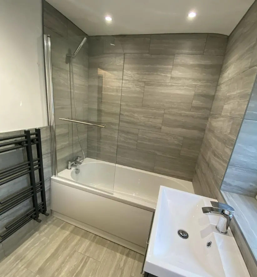 Family bathroom with bath, shower screen and black towel radiator